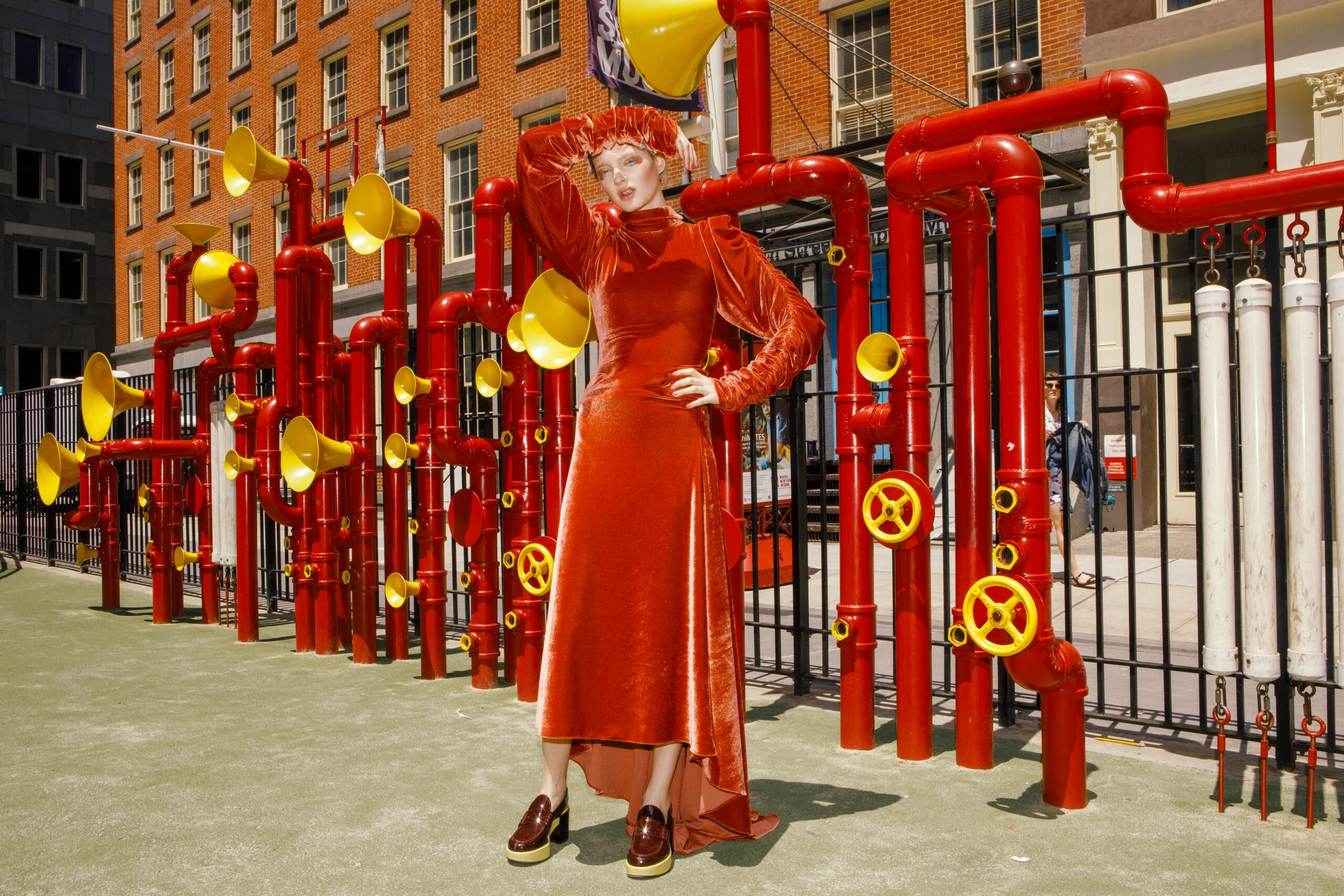 Model auf Spielplatz im roten Kleid in New York
