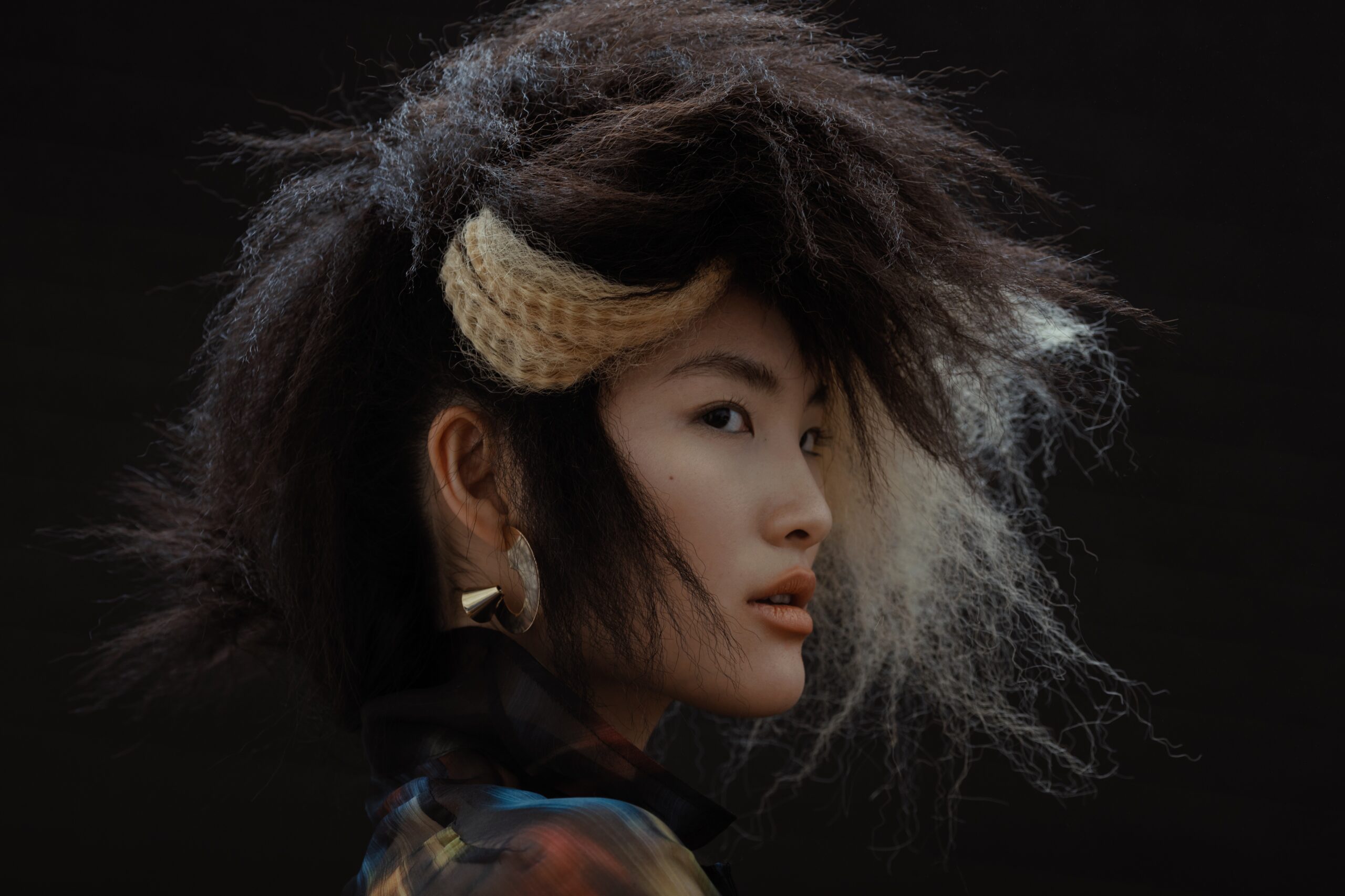 Asiatisches Model mit außergewöhnlicher Frisur und Ohrringen
