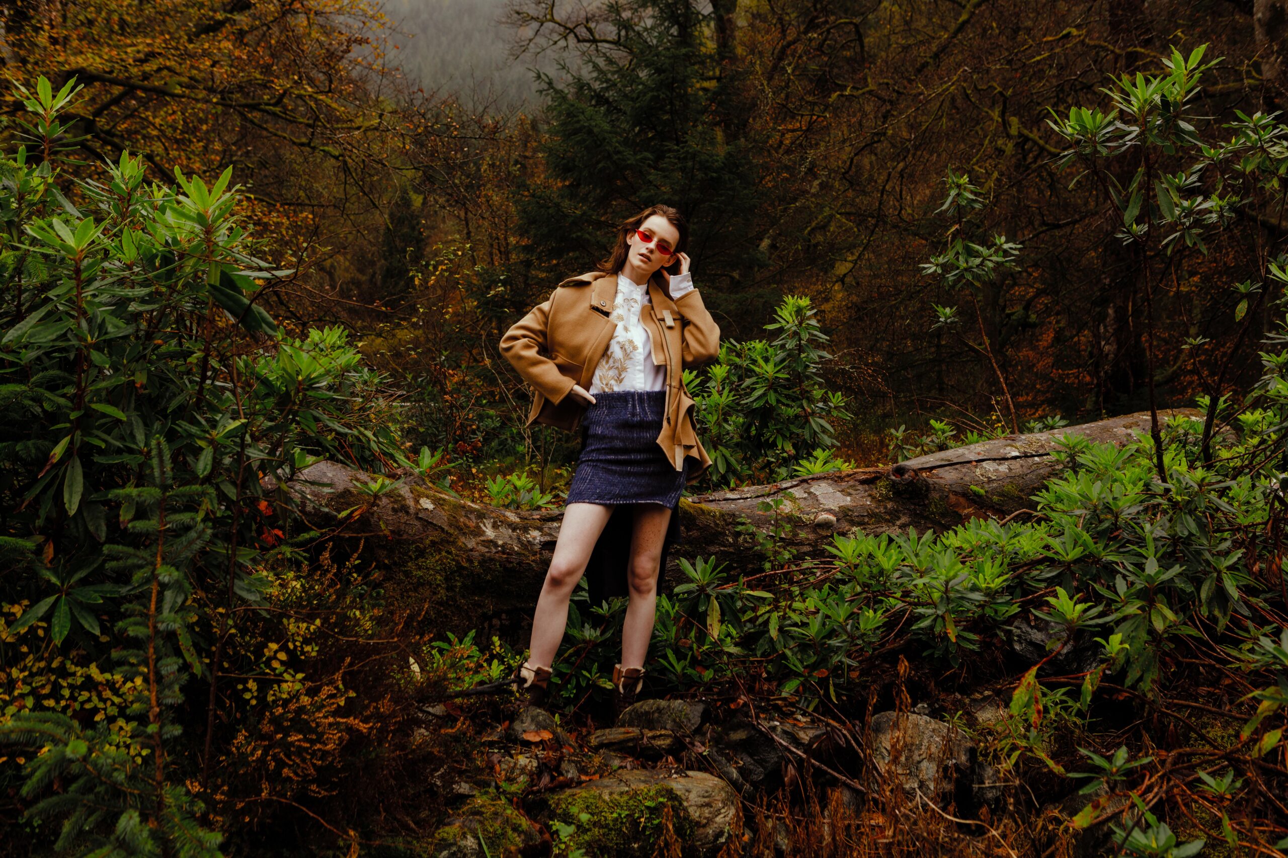 Weibliches Model steht im Wald in Schottland
